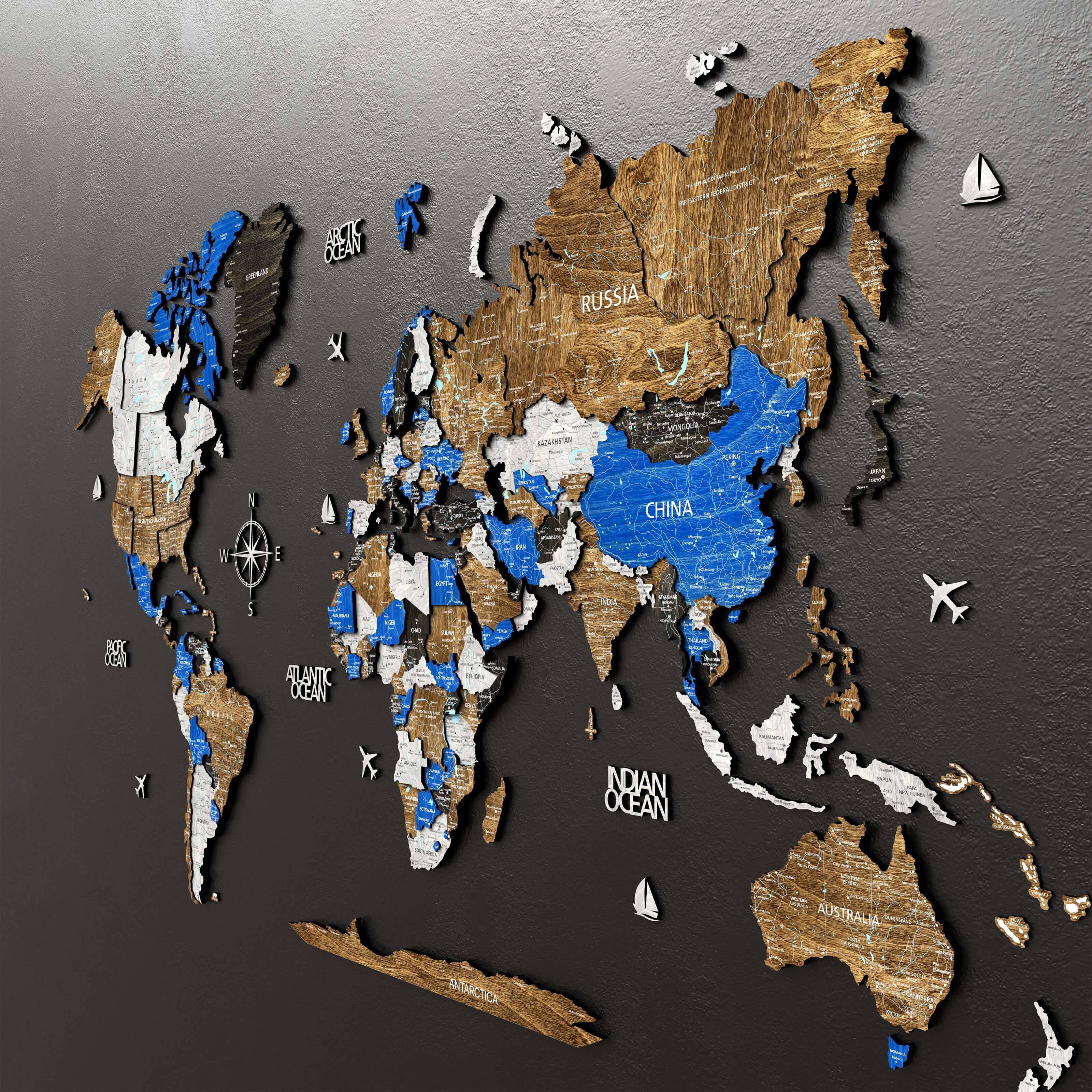 3D wooden world map in Scandinavian colors, showcasing countries, cities, and geographic features on a dark wall.