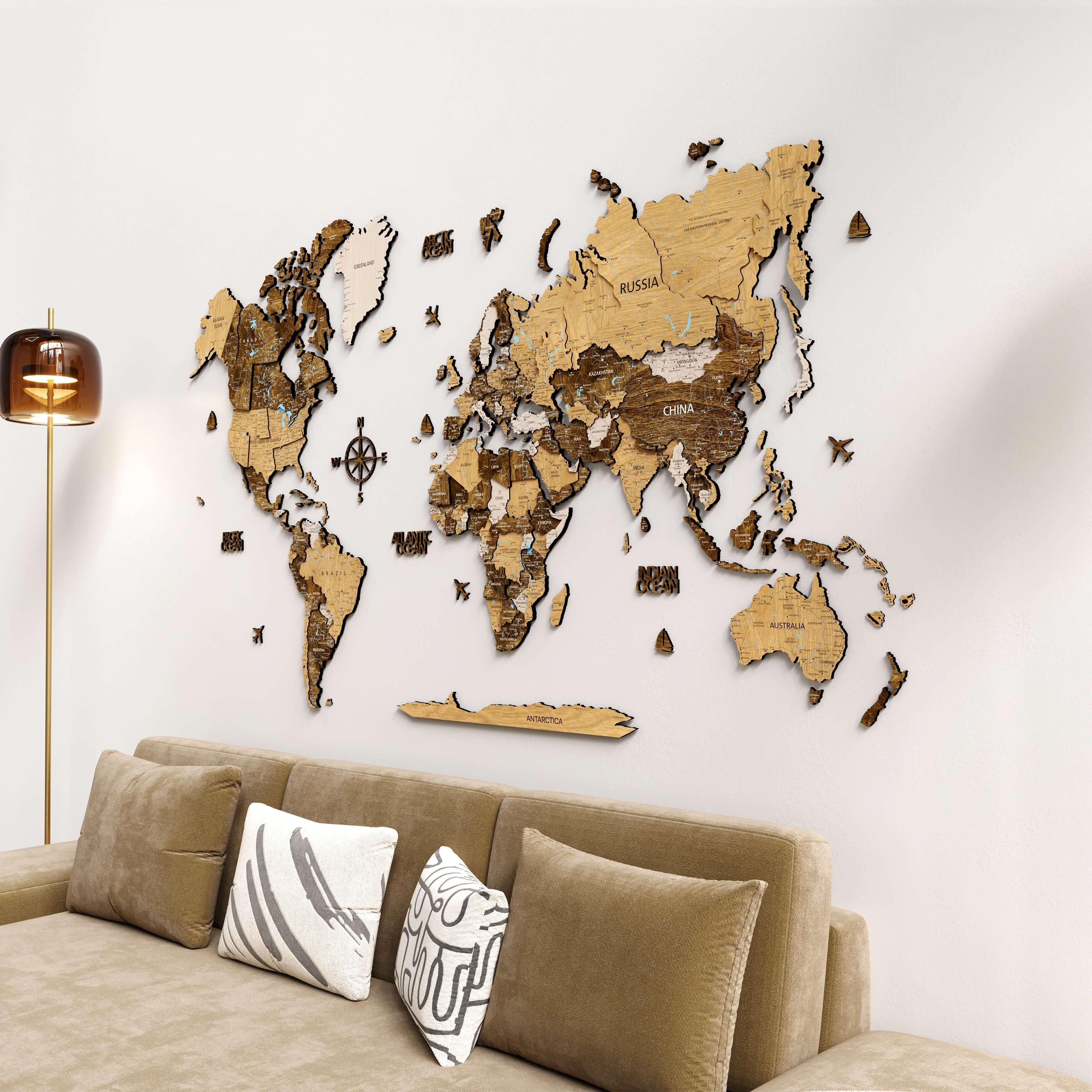 3D Wood world map wall decor displayed above a cozy sofa, featuring intricate oak wood details and geographical labels.