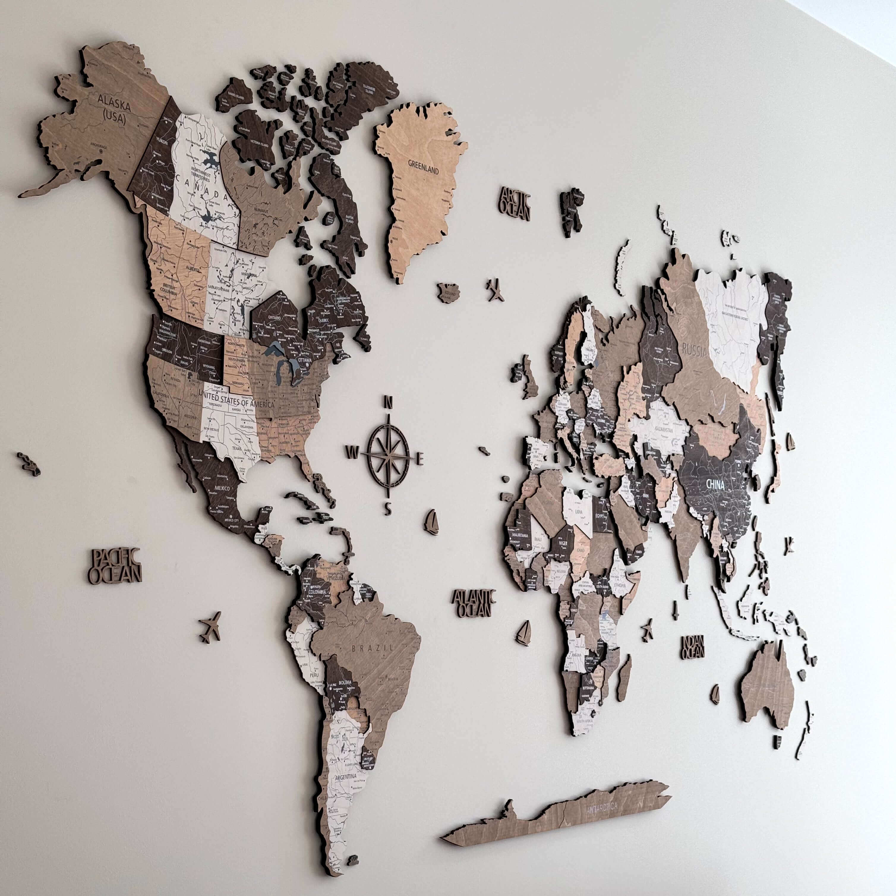 3D light brown wood world map wall art showcasing detailed continents and state outlines, adding warmth to interiors.