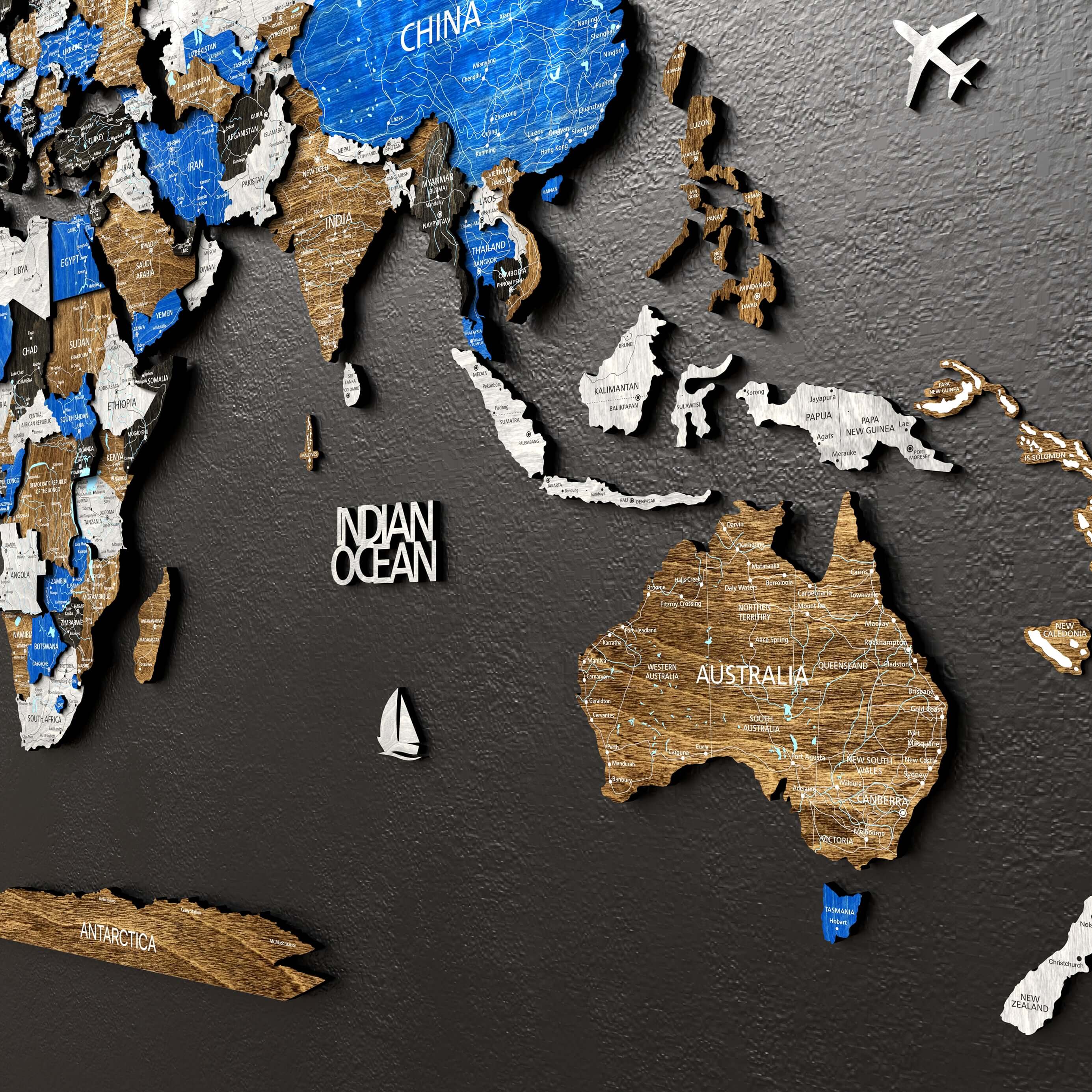 3D wooden world map with layered countries, cities, and oceans, featuring blue and natural wood finishes.