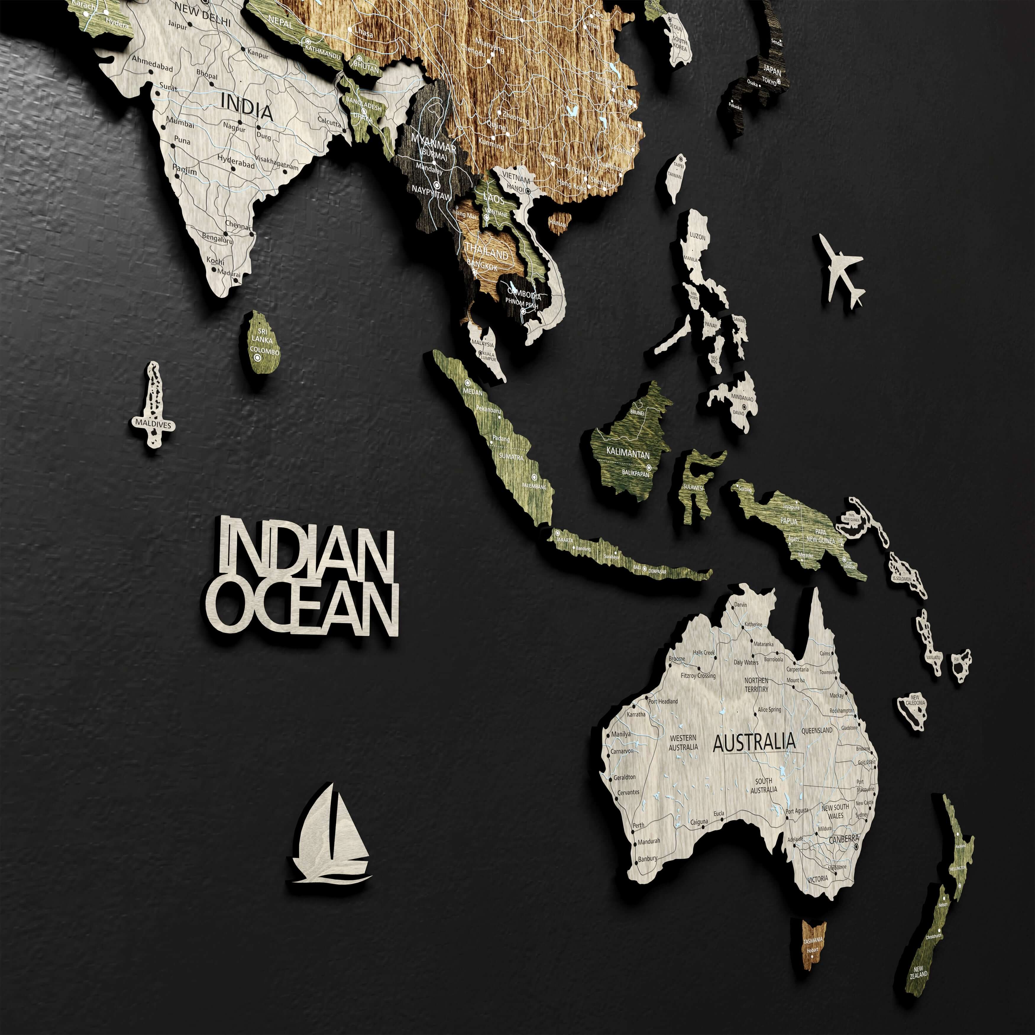 Close-up of push pins inserted into the 3D wooden world map, marking visited countries.