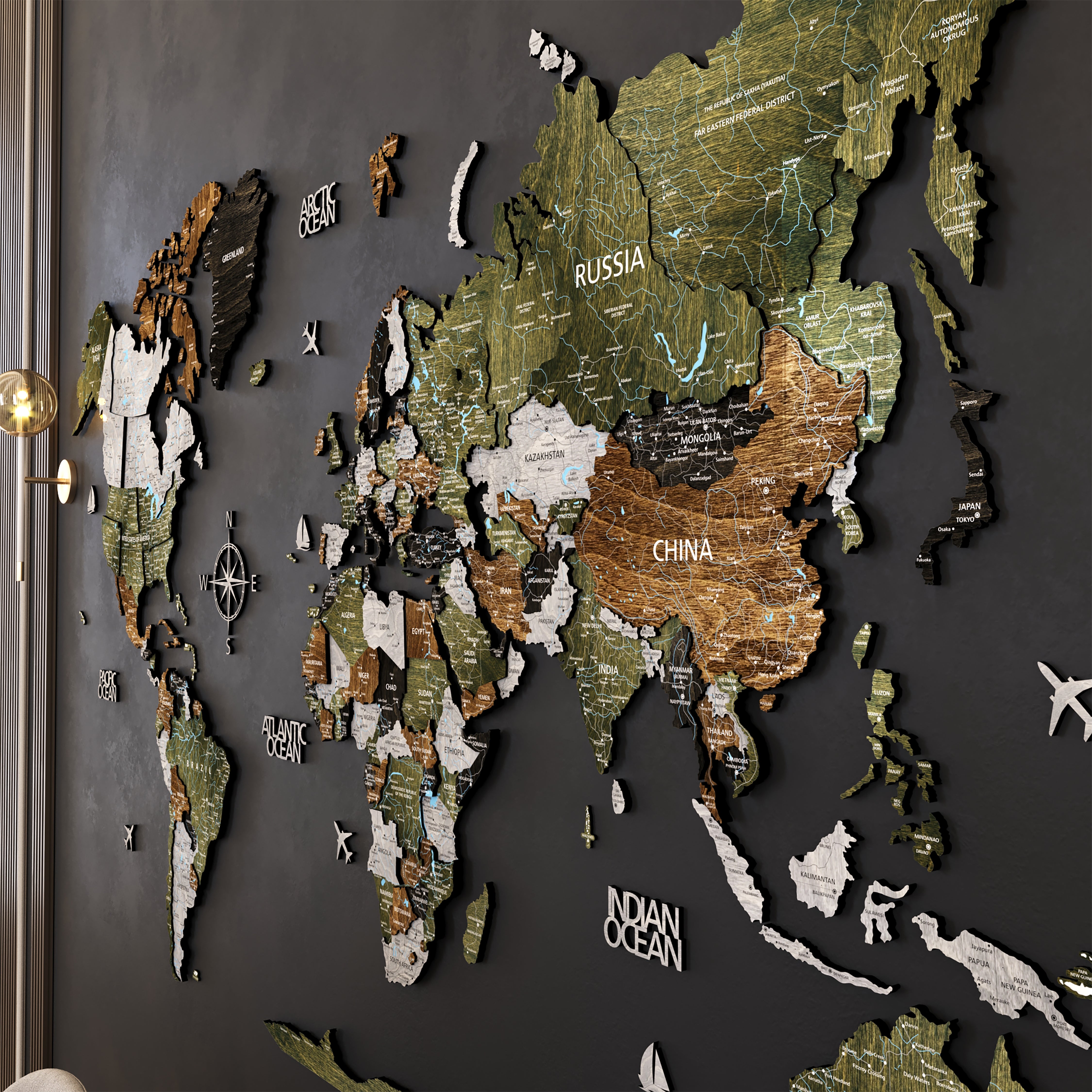 3D Wooden world map wall art in earthy tones displayed on a dark wall, highlighting continents like Russia and China.