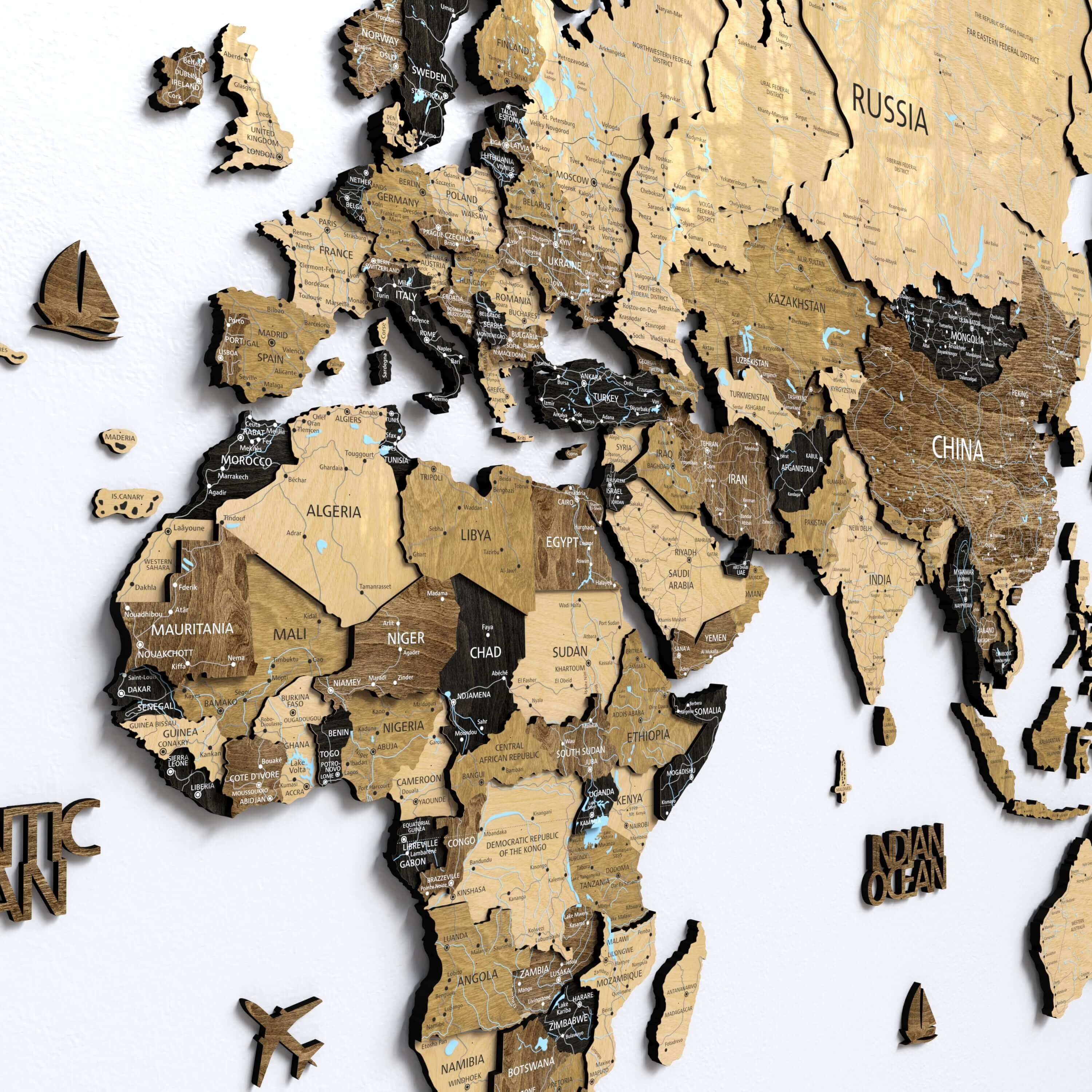 A dark brown 3D wooden world map mounted on a living room wall, serving as elegant home decor. The push pin map allows travelers to mark destinations, adding a personalized touch to the apartment's wall art.