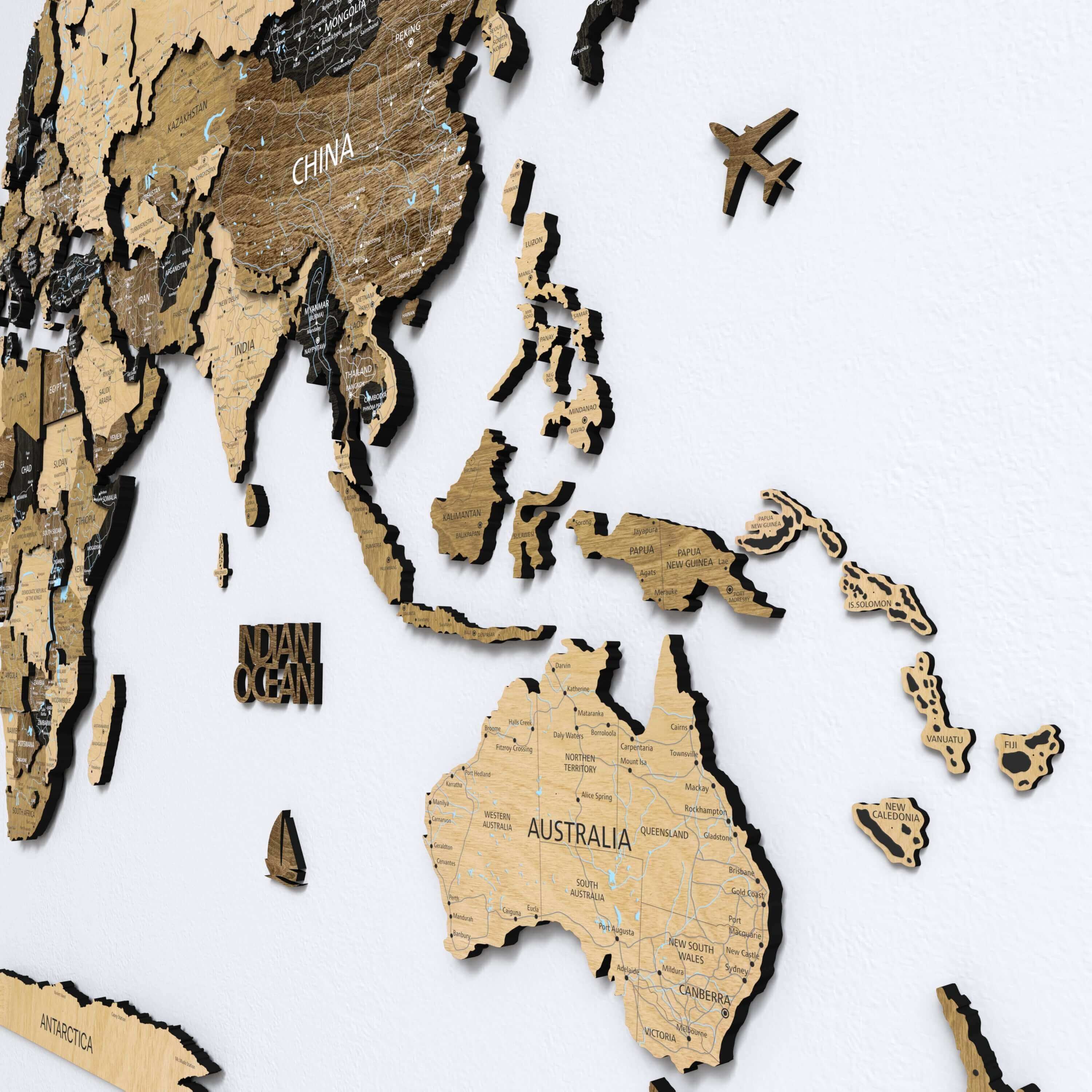 A close-up of a 3D dark brown wooden world map with printed country names. This push pin map offers a stylish and interactive decor piece, perfect for both apartment and home wall art.